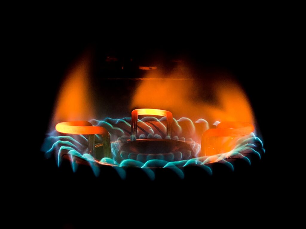 closeup shot of a beautiful blue green flame in a gas stove