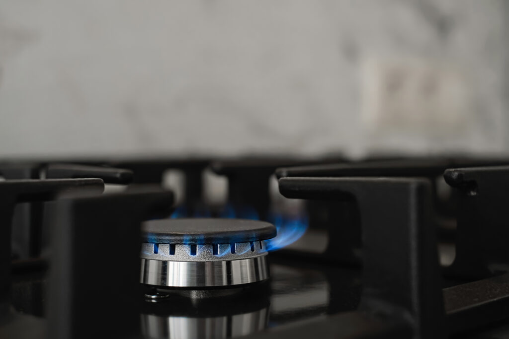 modern kitchen stove, natural gas burns with a blue flame. household gas consumption. close up, selective focus