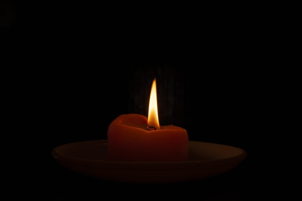 closeup shot of a burning candle in the dark